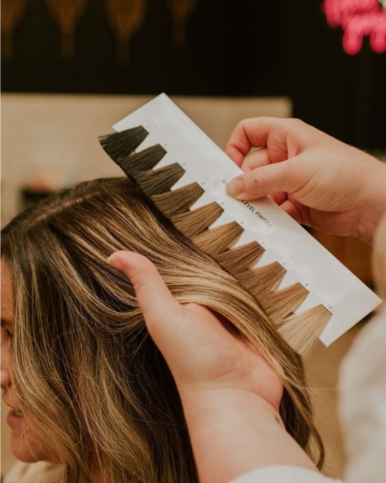 Carta de niveles de color sobre el cabello de una clienta durante la valoración